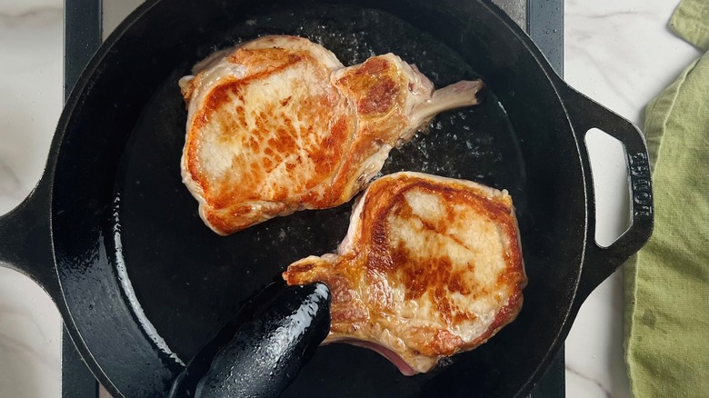 seared pork chops in skillet
