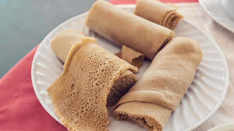 Rolled injera on a white plate