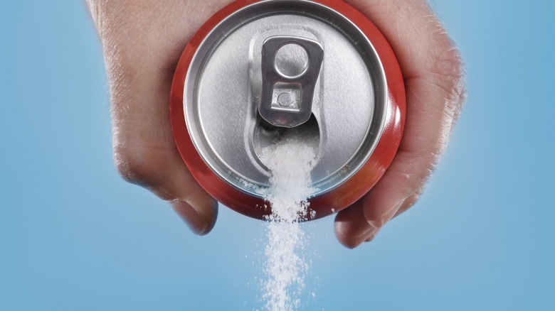 Soda can pouring out sugar crystals