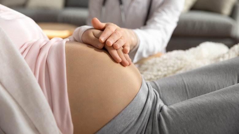 pregnant person holding bump