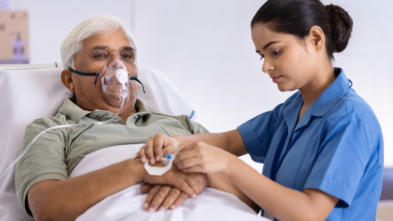 man in hospital bed receiving oxygen