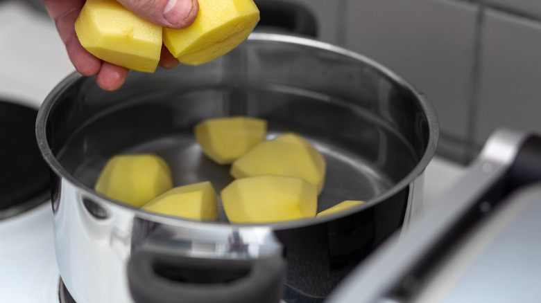 Peeled potatoes in saucepan