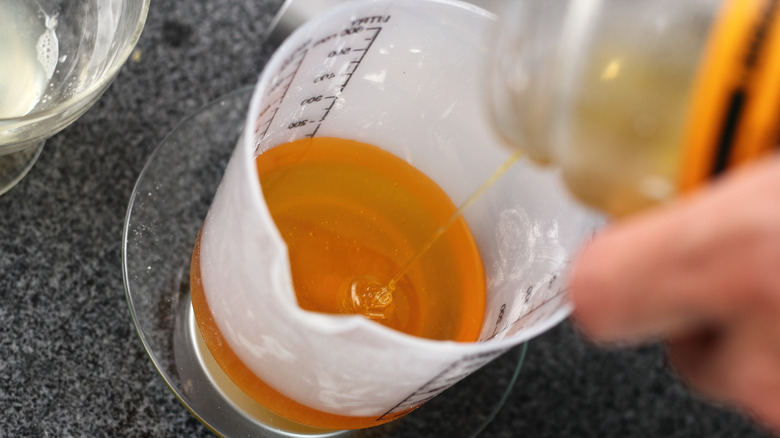 Pouring honey into measuring cup