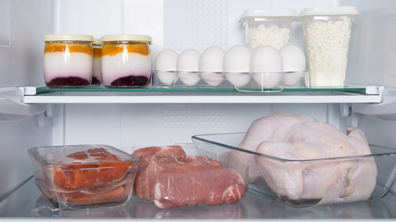 inside of a refrigerator with a whole chicken