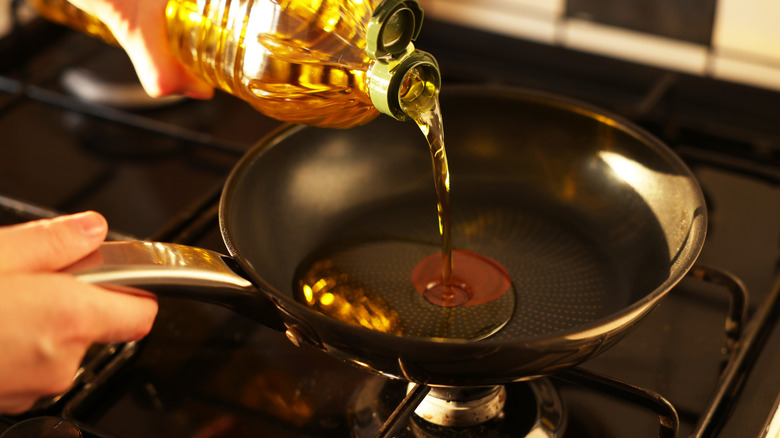 pouring oil into fry pan