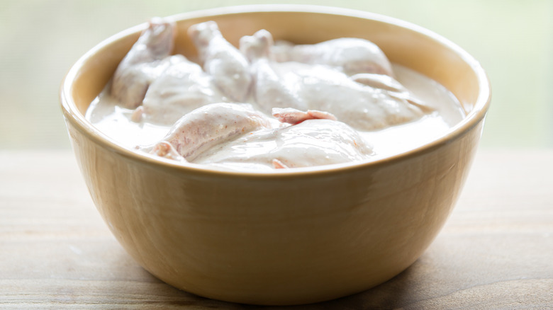 chicken in bowl of buttermilk marinade