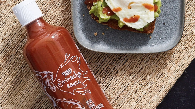 Trader Joe's Sriracha Sauce laid on tabletop next to plate of toast
