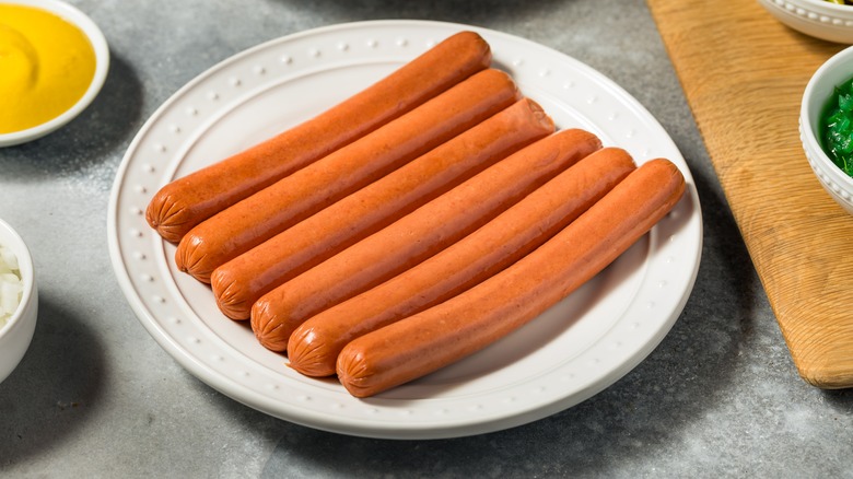 Uncooked hot dogs on plate