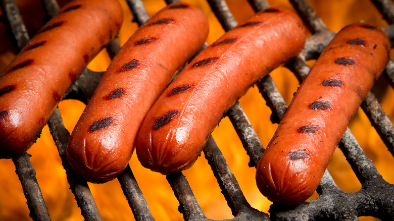 Hot dogs on flamed grill