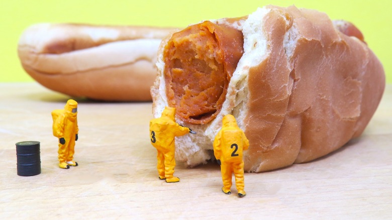 toy people investigate hot dog