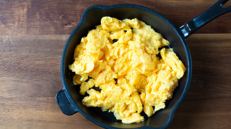 Frying pan of scrambled eggs on countertop