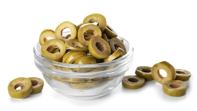Sliced green olives in glass bowl