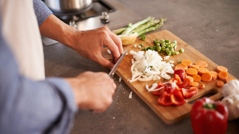 Person chopping various vegetables