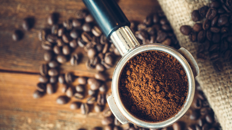 ground espresso, blurred beans in background