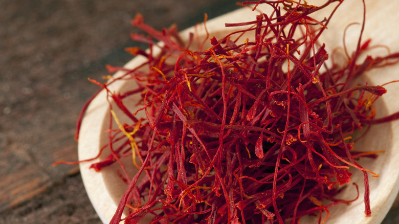 saffron threads piled in the bowl of a wooden spoon