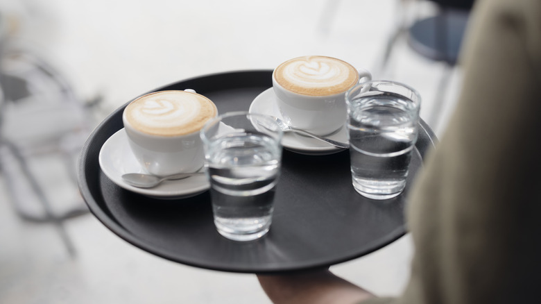 Lattes and water glasses on tray