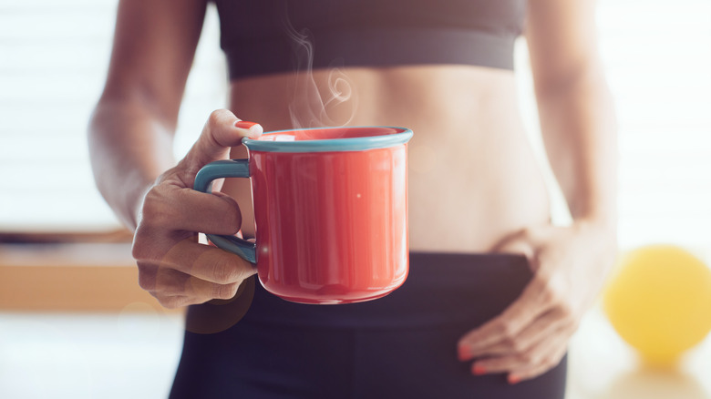 Woman in workout clothes with coffee mug