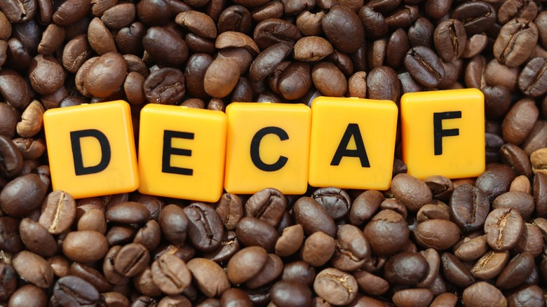 Coffee beans, yellow tiles spell "DECAF"