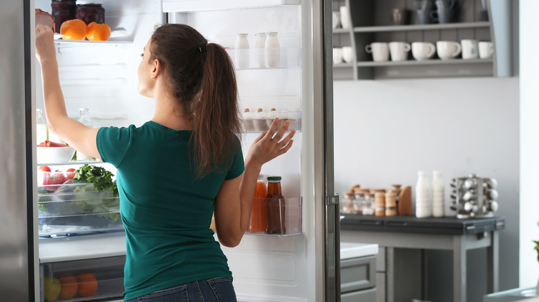 Woman reaching in refrigerator