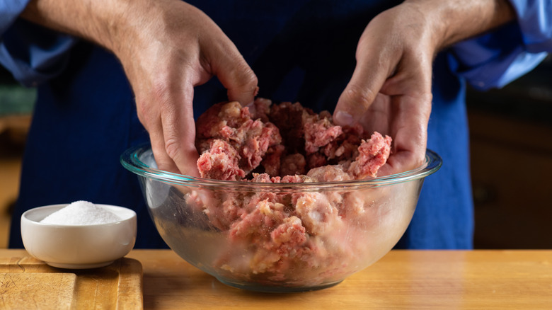 hands mixing meatloaf ingredients