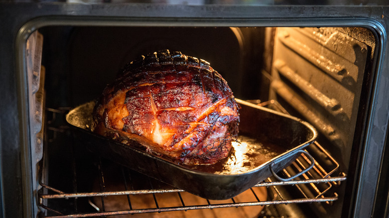 ham cooking in a pan in the oven