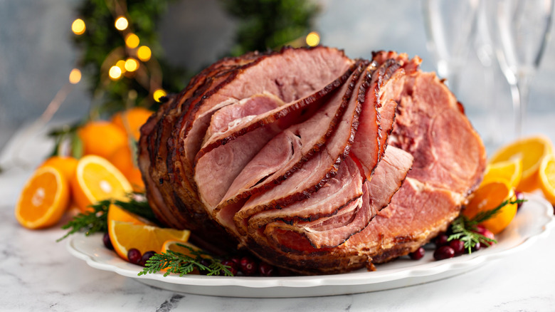 carved ham on a white platter