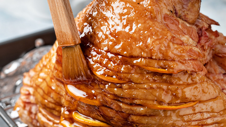 brushing a sweet glaze on the ham