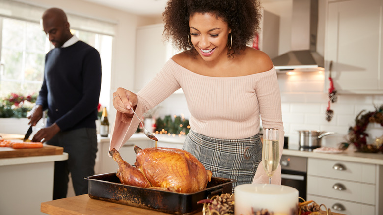 Woman basting a turkey