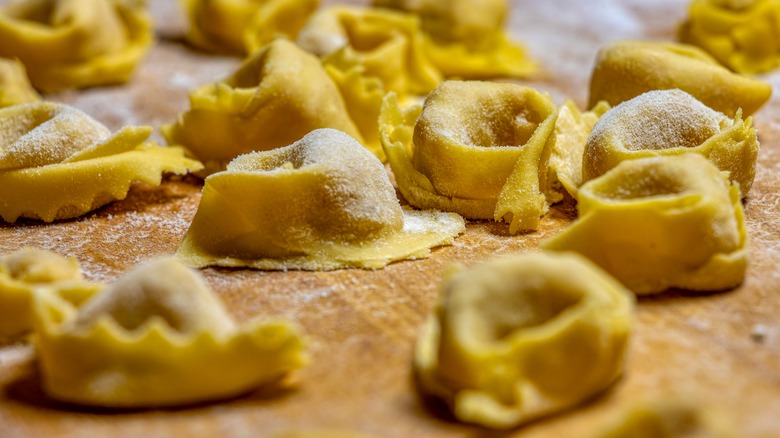 Fresh uncooked marubini pasta on board