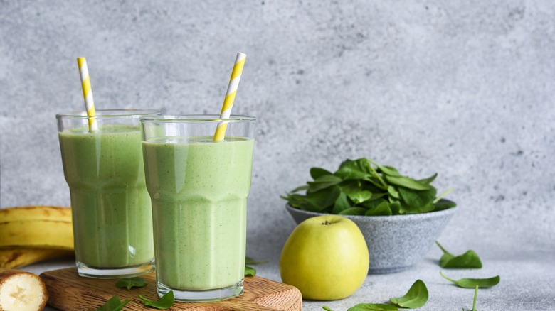 green smoothies and fruit on cutting board