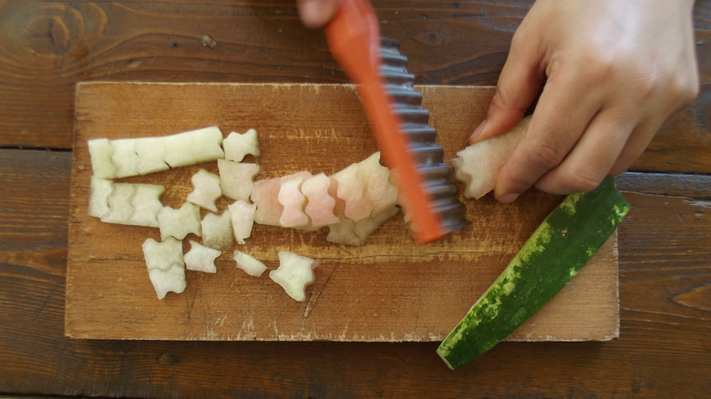 watermelon rind being decoratively cut for salad