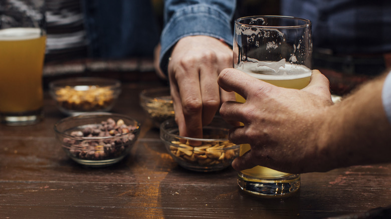 hands with bar nuts and beers 