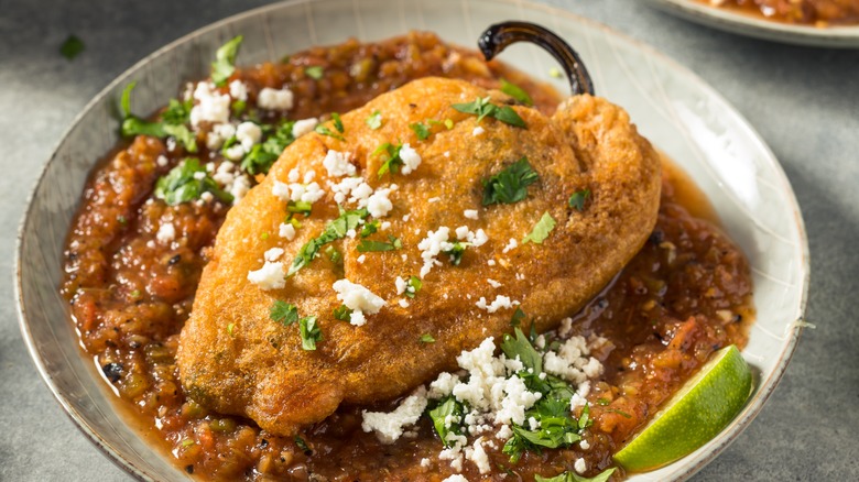 Plate with homemade chili relleno on a bed of salsa