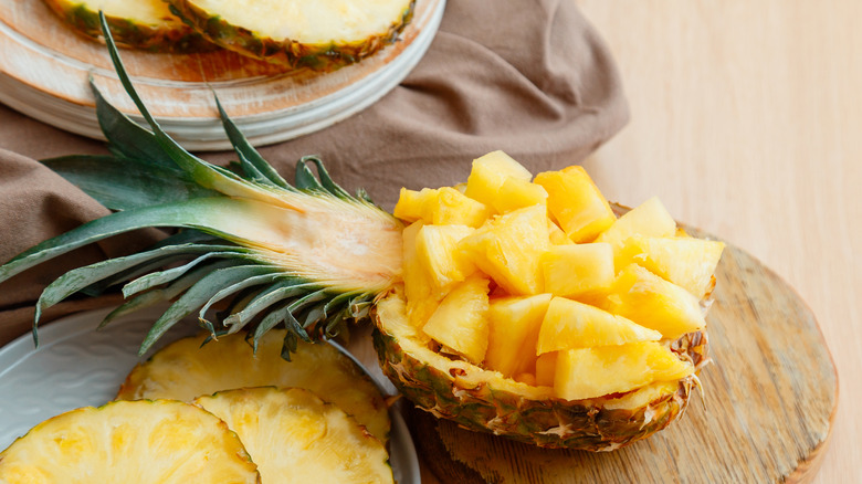 chopped up pineapple presented in half of a pineapple