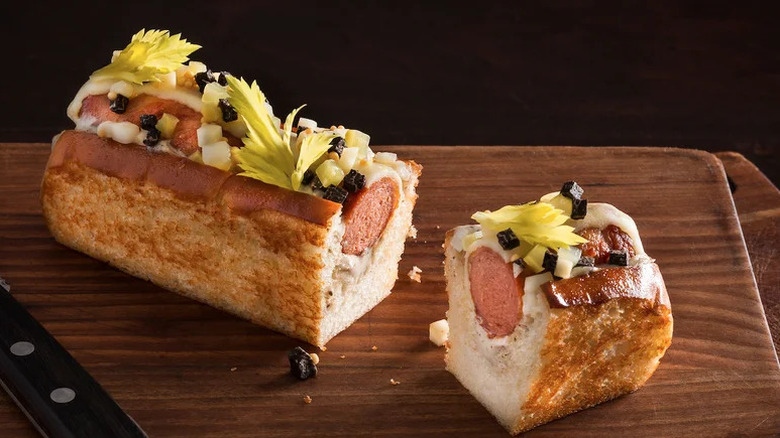 a gourmet hotdog topped with black truffle and aioli