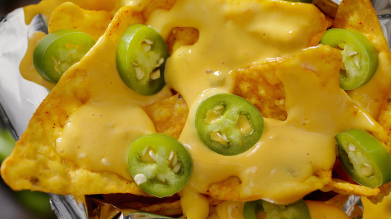 nacho chips with cheese sauce and jalapeños 