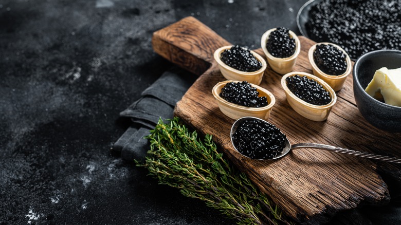 samples of caviar on a wooden tray