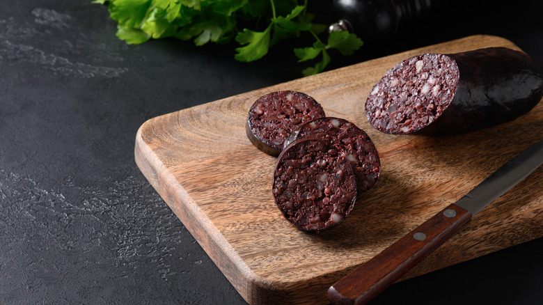 slices of black pudding and cut roll on cutting board