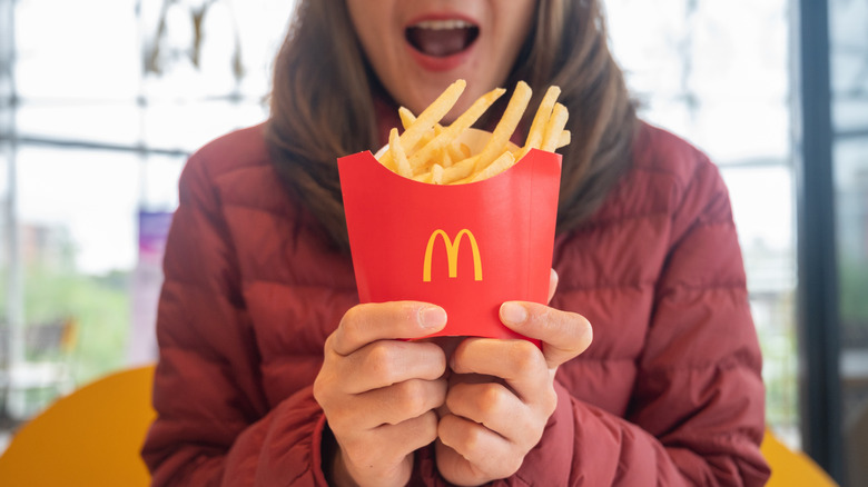 holding a box of fries