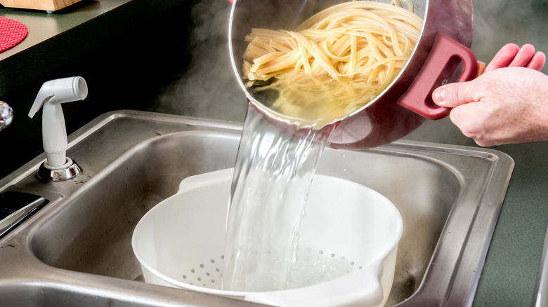 pouring pasta water through strainer