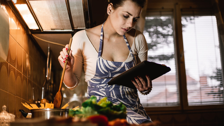 woman cooking with digital recipe