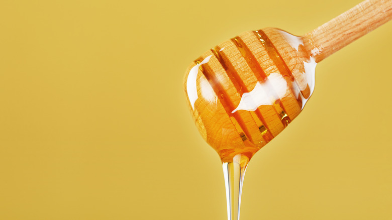 Honey dripping from wooden utensil