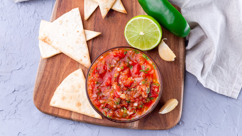 Bowl of salsa with lime, jalapeño, and chips