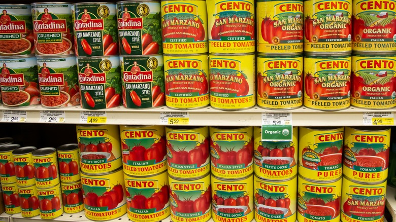 Grocery shelf full of various canned tomatoes