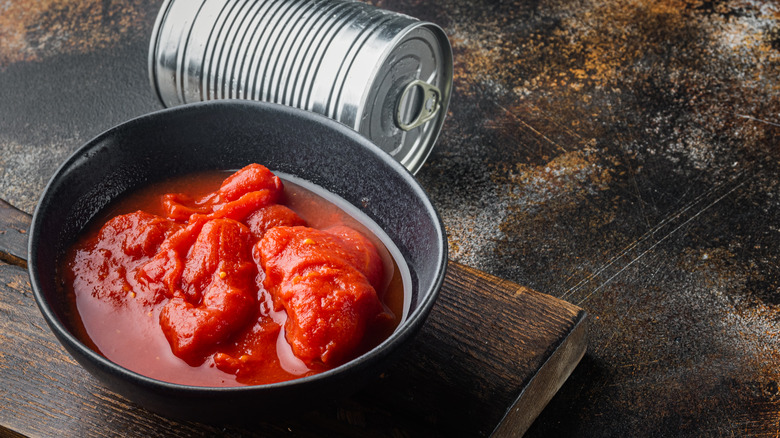 Peeled tomatoes in bowl with juice