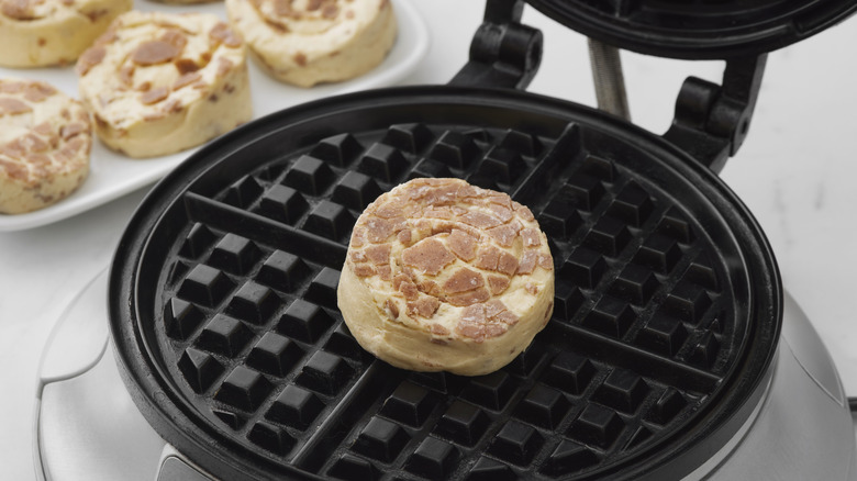 a store bought cinnamon roll sitting on a waffle iron