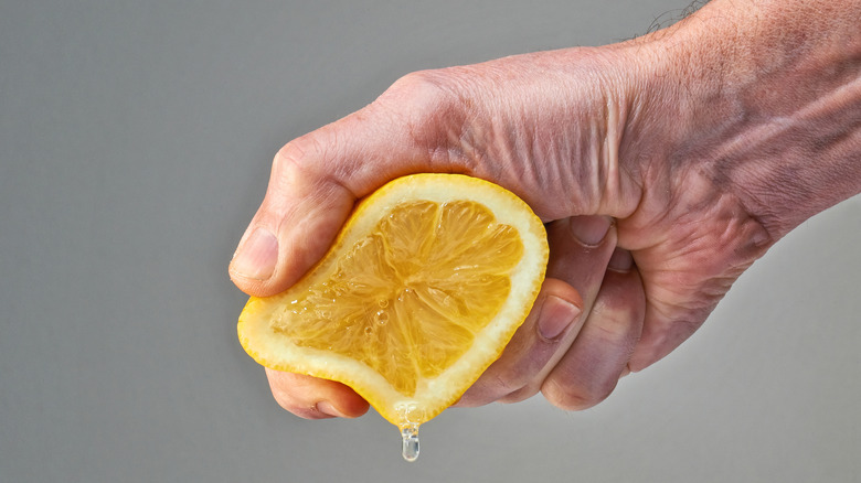 hand squeezing lemon half