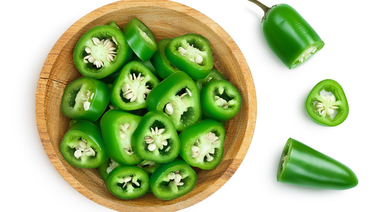 sliced jalapeño in wooden bowl