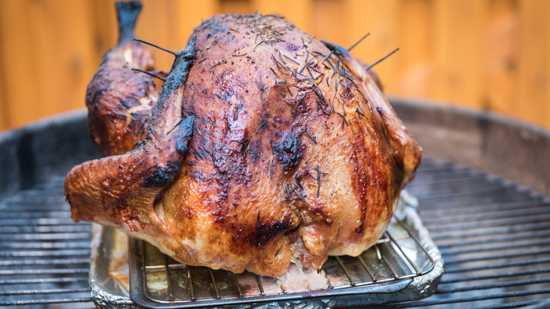 Cooked turkey in a pan on a grill grate