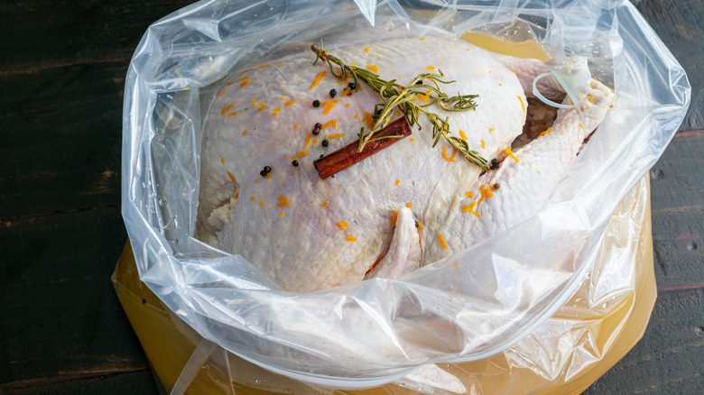 Raw turkey resting in plastic bag with seasoning liquid